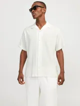 Camisa blanca de popelina con cuello resort, mangas cortas y cierre frontal con botones.