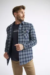 Sobrecamisa de viyela para hombre con estampado de cuadros en rojo y negro. Presenta cierre frontal con botones, bolsillos en el pecho con solapa y botón, y un interior capitoneado para mayor abrigo. Cuenta con un logo en grifa de cuero.