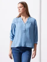 Blusa celeste de lyocell con cuello a la base, escote en V con botones y mangas 3/4 con puño abotonado.