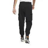 Pantalón de jogging negro de corte ajustado con puños elásticos, bolsillos laterales y bolsillo cargo con solapa en el muslo derecho. Logo de Nike bordado en blanco en el muslo izquierdo.