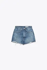 Minifalda de denim azul con tiro medio, trabillas, cinco bolsillos, roturas y bajo desflecado.