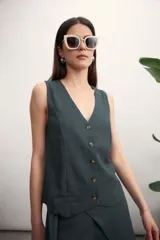 Chaleco negro con escote en V y cierre frontal con botones. Corte recto y sin mangas.