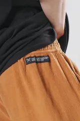 Bermuda color ocre de algodón con elástico en la cintura, cordón de ajuste con ojalillos y dos bolsillos delanteros.