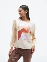 Blusa azul con estampado geométrico en blanco y negro, de mangas largas y cuello redondo.