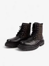 Botas de cuero color marrón con caña media y cordones negros. Presentan un diseño geométrico en la parte superior de la caña y suela track color negro.