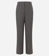 Pantalón de vestir gris claro, de corte recto, con bolsillos laterales y traseros. Se ajusta a la cintura con cinturón de cuero negro.