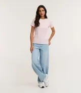 Remera tipo t-shirt de algodón, color beige claro, con cuello redondo y mangas cortas dobladas.