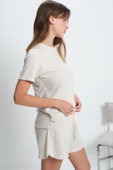 Short de punto color beige con cintura elástica y cordón ajustable.