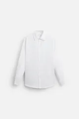 Camisa blanca de corte regular, cuello italiano, manga larga con puños abotonados y cierre frontal con botones.