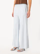 Pantalón celeste de corte palazzo, con cintura elástica y botones a presión en los laterales.