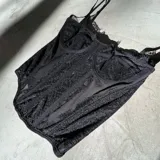 Corset negro de encaje con copas preformadas, breteles finos regulables y ballenas de soporte.