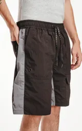 Bermuda deportiva color negro con paneles laterales grises. Presenta cintura elástica con cordón de ajuste estampado, bolsillos laterales y un bolsillo cargo con solapa en el muslo derecho.