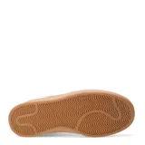 Zapatillas deportivas negras con detalles en blanco y suela color caramelo.