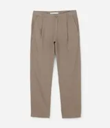 Pantalón de hombre color beige/marrón claro, de corte recto y tiro medio, con pinzas frontales y cierre de botón y cremallera. Presenta bolsillos laterales tipo cuchillo.
