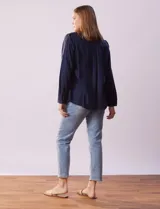 Camisa blanca de lyocell, marca Dash. Tiene cuello con solapa, abertura central con botones, mangas largas regulables con presilla y botón, y dos bolsillos delanteros aplicados.