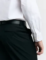 Traje de vestir color marrón topo, compuesto por saco de dos botones con solapa de muesca, dos bolsillos delanteros con solapa y un bolsillo superior. Pantalón de vestir con corte recto y bolsillos laterales. Incluye camisa blanca y corbata azul con lunares blancos.