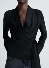 Blusa negra cruzada con cuello pico con solapa y lazo lateral.