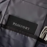 Bandolera negra de poliéster impermeable con detalles en simil cuero. Diseño ultrafino y ligero, con correa reforzada para uso en ambos hombros. Incluye bolsillo delantero con velcro, bolsillo trasero antirrobo con cierre y espacio para tablet de hasta 7 pulgadas.