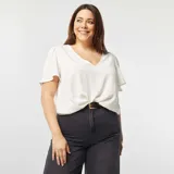 Blusa blanca de textura arrugada, con escote en V y mangas cortas abullonadas.