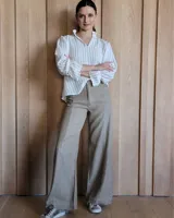 Pantalón de jean de corte ancho, color beige, con bolsillos delanteros y traseros.