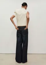 Pantalón de jean azul oscuro, corte wide leg, tiro bajo, con cinco bolsillos y cierre frontal con cremallera y botón.