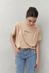 Remera color beige de manga corta con bordado frontal con la frase “L’amour toujours”.