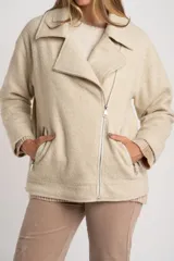 Campera de abrigo color crema, con cuello solapa y cierre frontal asimétrico. Presenta textura bouclé o de lana rizada.