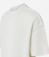 Remera oversized de algodón color crudo, con cuello redondo, manga corta, sin estampa y ribete acanalado.
