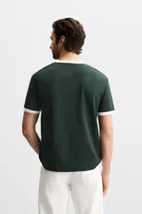 Camiseta azul marino de corte regular, cuello redondo y manga corta con ribete blanco en cuello y mangas.