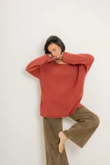 Buzo verde militar de tejido liviano con acabado gastado, corte oversize, cuello bote y mangas largas con hombro caído.