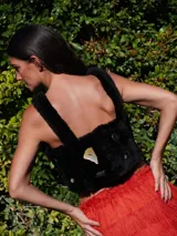 Top corto de corderito color crudo, con breteles y cierre con broches en la espalda. Decorado con pins y tachas variadas.