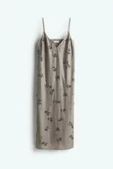 Vestido midi color gris con breteles finos y escote en V. Presenta bordado floral con cuentas de vidrio. Tiene forro interior y abertura lateral en el ruedo.