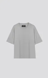 Remera gris de corte crop y calce oversize, con hombros caídos y cuello redondo.