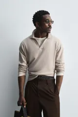 Sweater tipo polo color beige, de punto con mezcla de algodón y lana, corte regular fit, cuello solapa con abertura en V y mangas largas con terminaciones en rib.