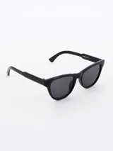 Lentes de sol negros con montura cat-eye y lentes oscuros.