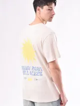 Remera color beige con estampado pequeño en el pecho.