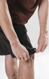 Bermuda cargo negra de nylon y spandex, con calce relax-fit, cintura elástica, cordón de ajuste y bolsillos delanteros con fuelle.
