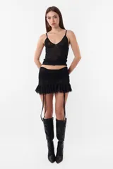 Minifalda negra de microtul con cintura ancha fruncida y tiras ajustables.