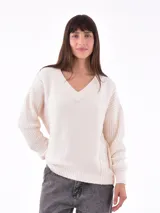 Sweater tejido color crudo, con escote en V y mangas largas.