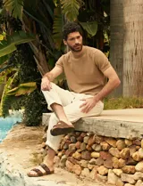 Remera de tejido de punto color marrón claro, de manga corta y cuello redondo.