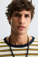 Camiseta de hombre de corte relajado, color crudo con rayas horizontales color ocre y cuello redondo azul marino en contraste.