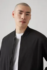 Campera bomber negra con cierre frontal, cuello redondo y bolsillos laterales.