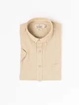 Camisa de hombre color verde oliva, de manga corta y corte clásico. Confeccionada en lino y poliéster, con cuello abotonado y bolsillo en el pecho.