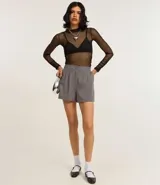 Blusa de tule transparente color negro, con cuello alto y mangas largas.