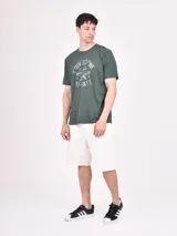 Remera verde con estampado circular con texto y alas.