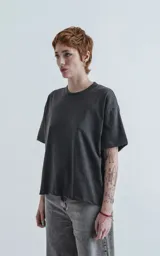 Remera manga corta gris oscuro, de cuello redondo y calce boxy fit.