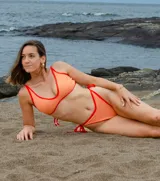Top de bikini color naranja con contorno y tirantes en rojo.