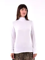 Polera blanca de cuello alto y manga larga.