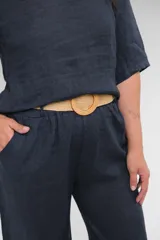 Pantalón de lino azul marino, de corte recto y tiro medio. Incluye cinturón de soga color beige.