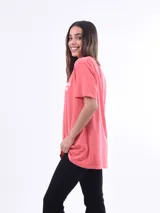 Remera color salmón con estampado frontal con la frase "The Beach Club" en letras blancas.